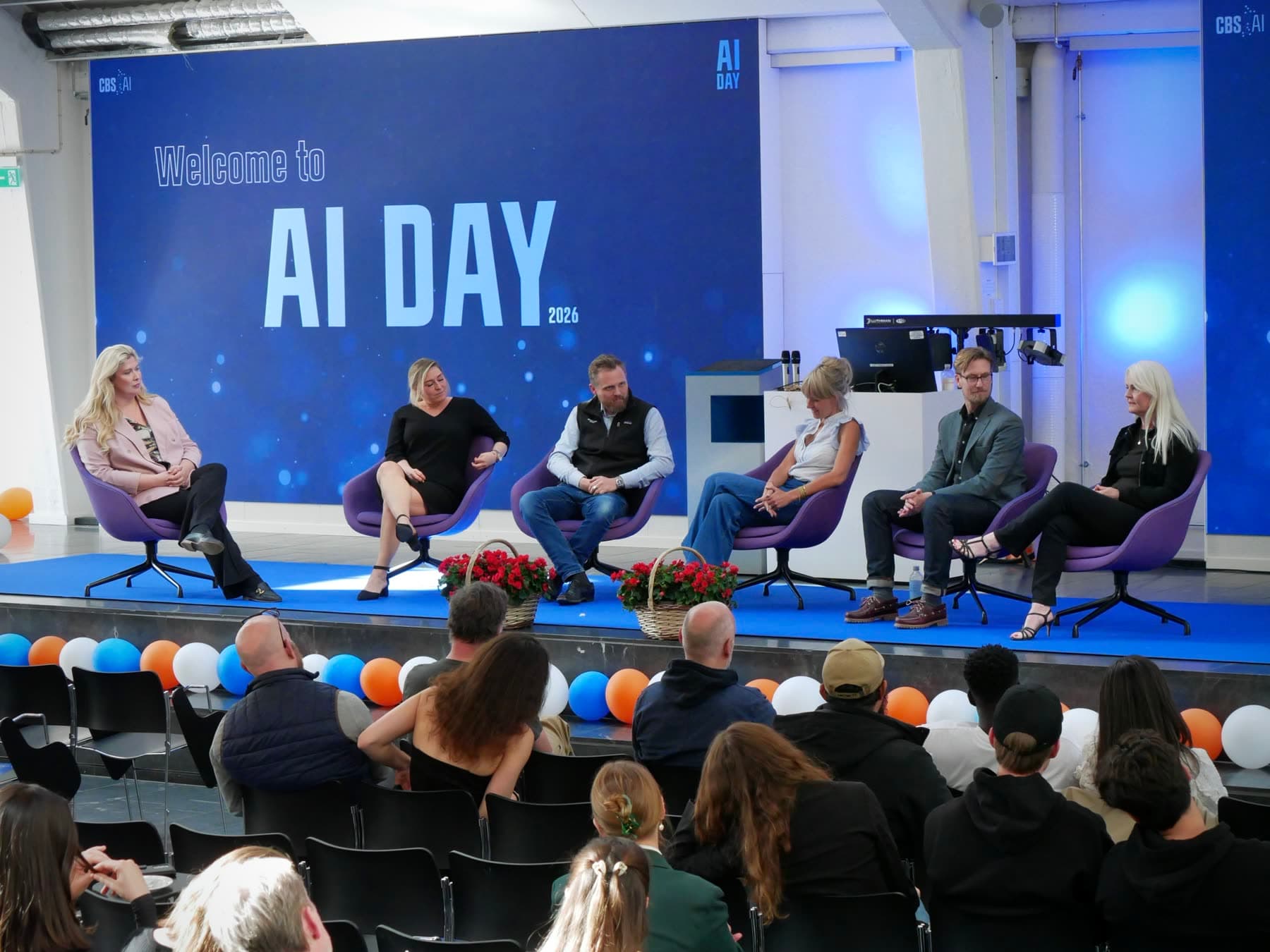 Six panellists on stage at CBS AI Day with the audience in the foreground