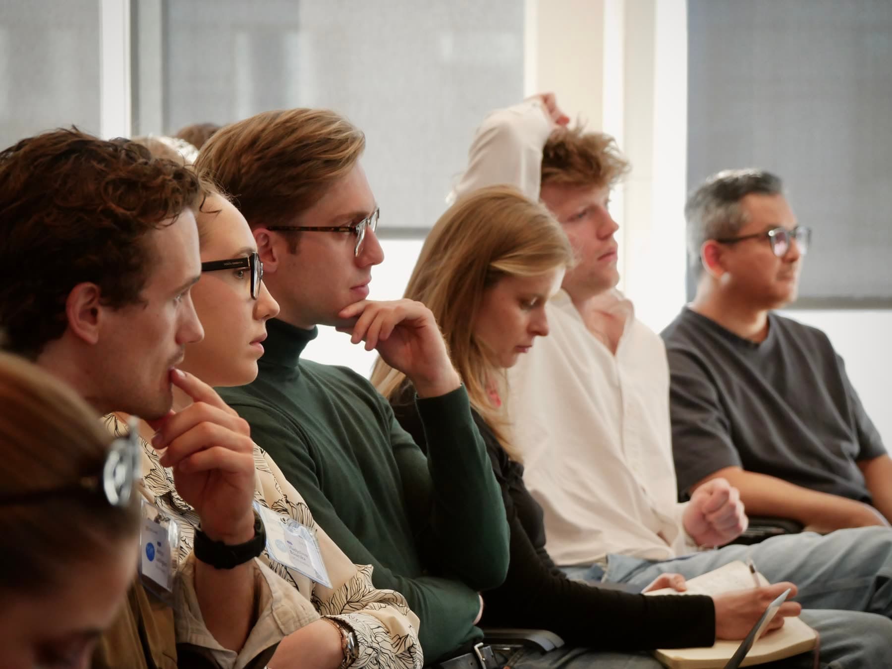 Students seated in a row, listening and taking notes during a CBS AI session