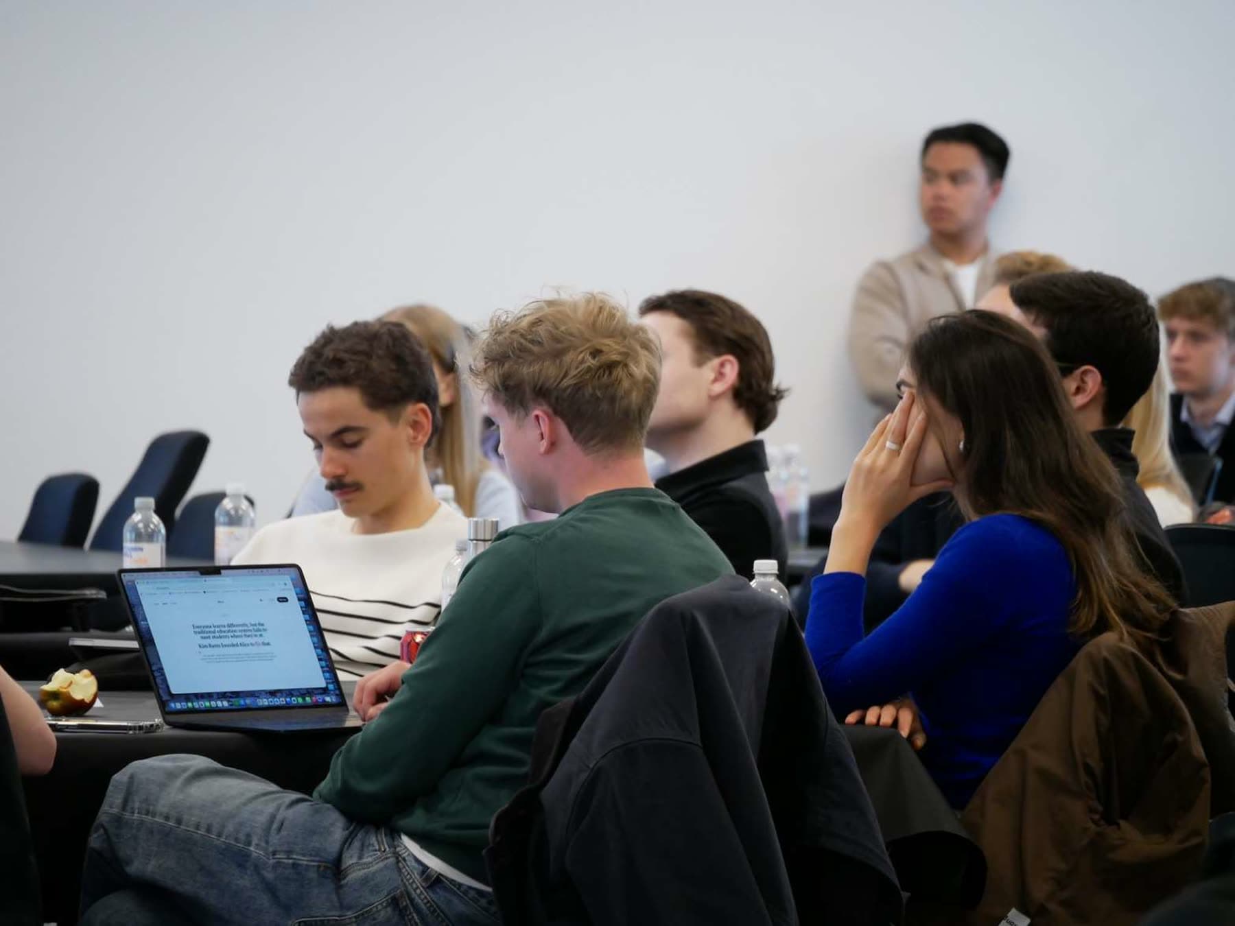 Students working together around laptops during an Academy workshop